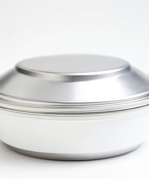 A stainless steel lunch box isolated on a white background. The lunch box is a popular choice for those who want to pack their own lunch, as it is durable, leak-proof, and easy to clean.