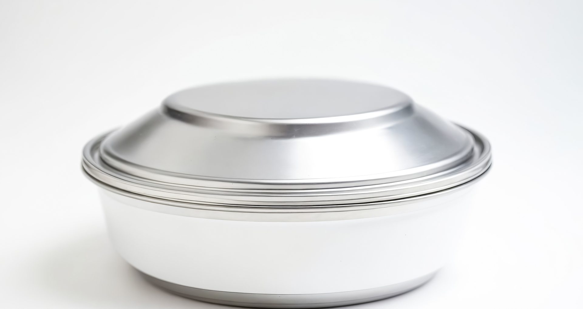 A stainless steel lunch box isolated on a white background. The lunch box is a popular choice for those who want to pack their own lunch, as it is durable, leak-proof, and easy to clean.
